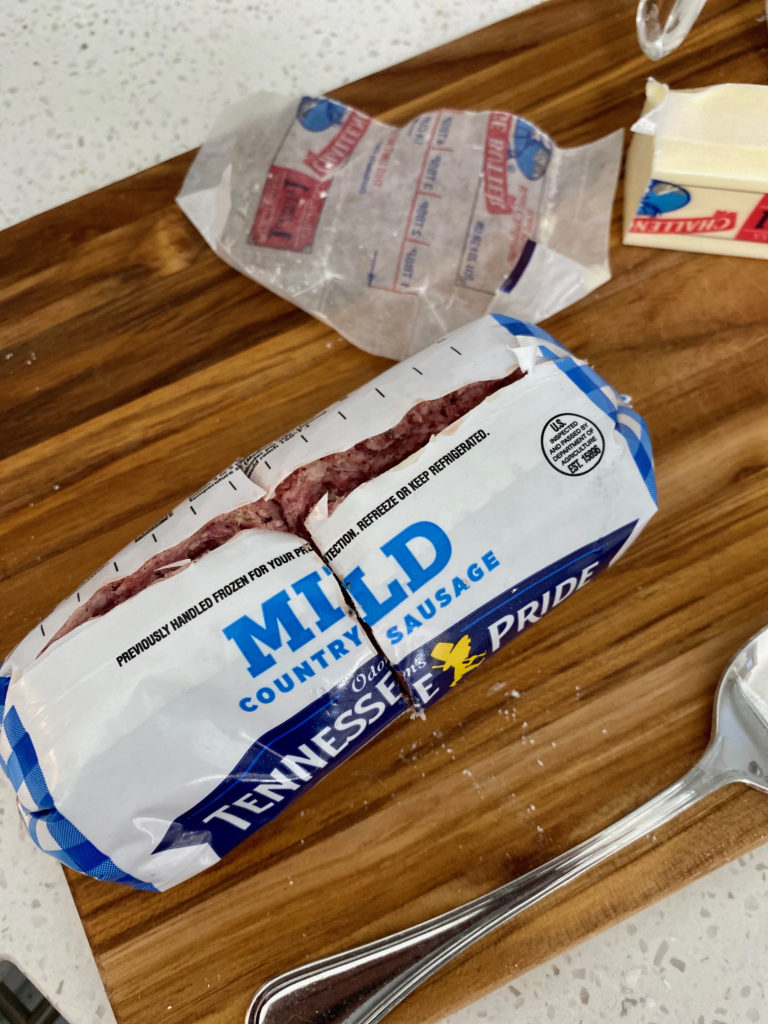 A package of pork sausage being sliced open. [Biscuits and Gravy]