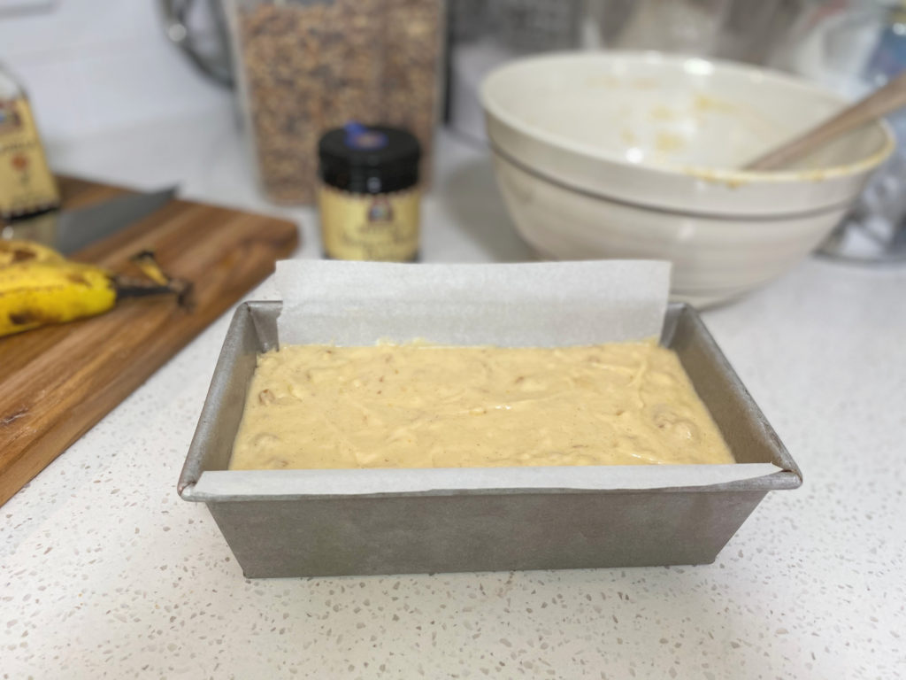 A loaf pan filled with uncooked banana bread batter. [decadent banana bread]