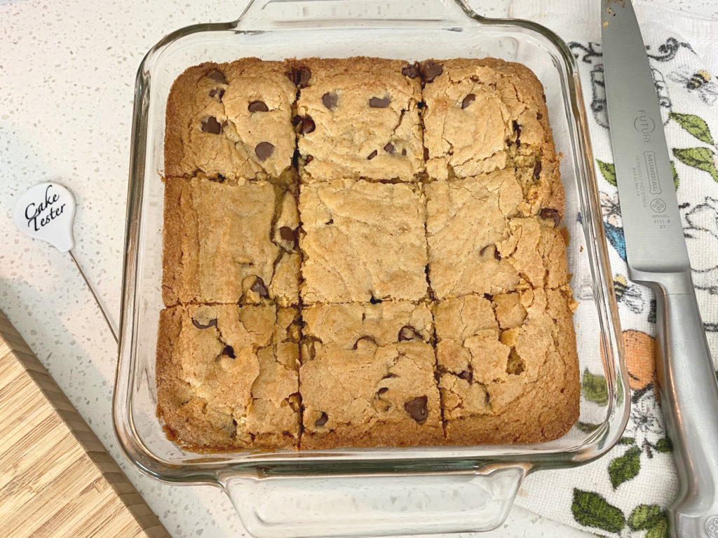 Fresh-baked chocolate chip cookie bars in a glass baking dish, cut into squares. [chocolate chip cookie bars]