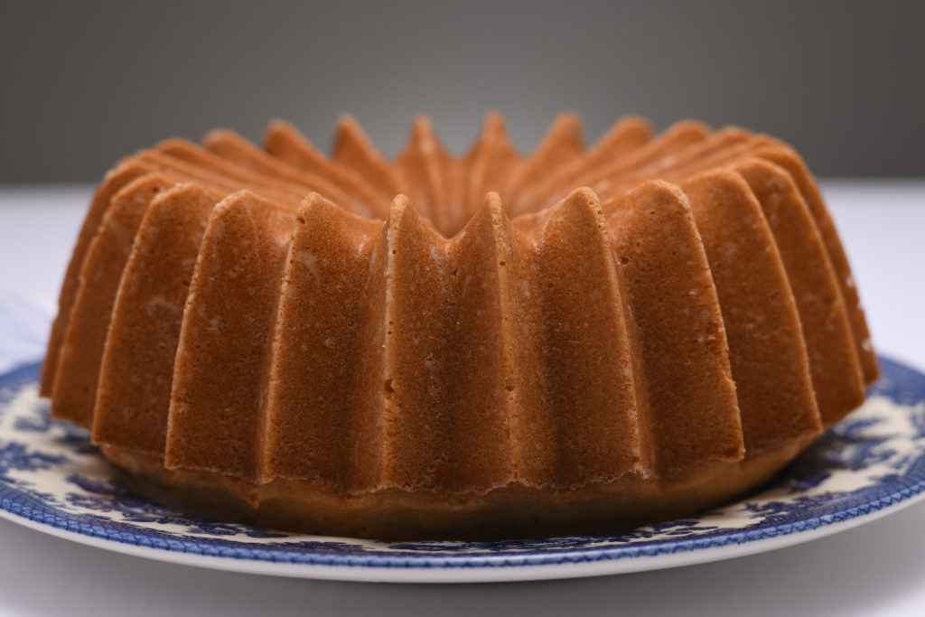 A whole pound cake on a blue patterned cake plate. [Perfect Pound Cake]