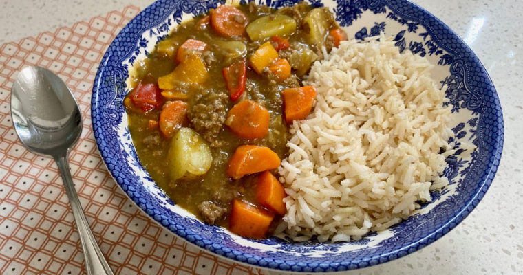 A bowl of Japanese Curry with chicken and rice.