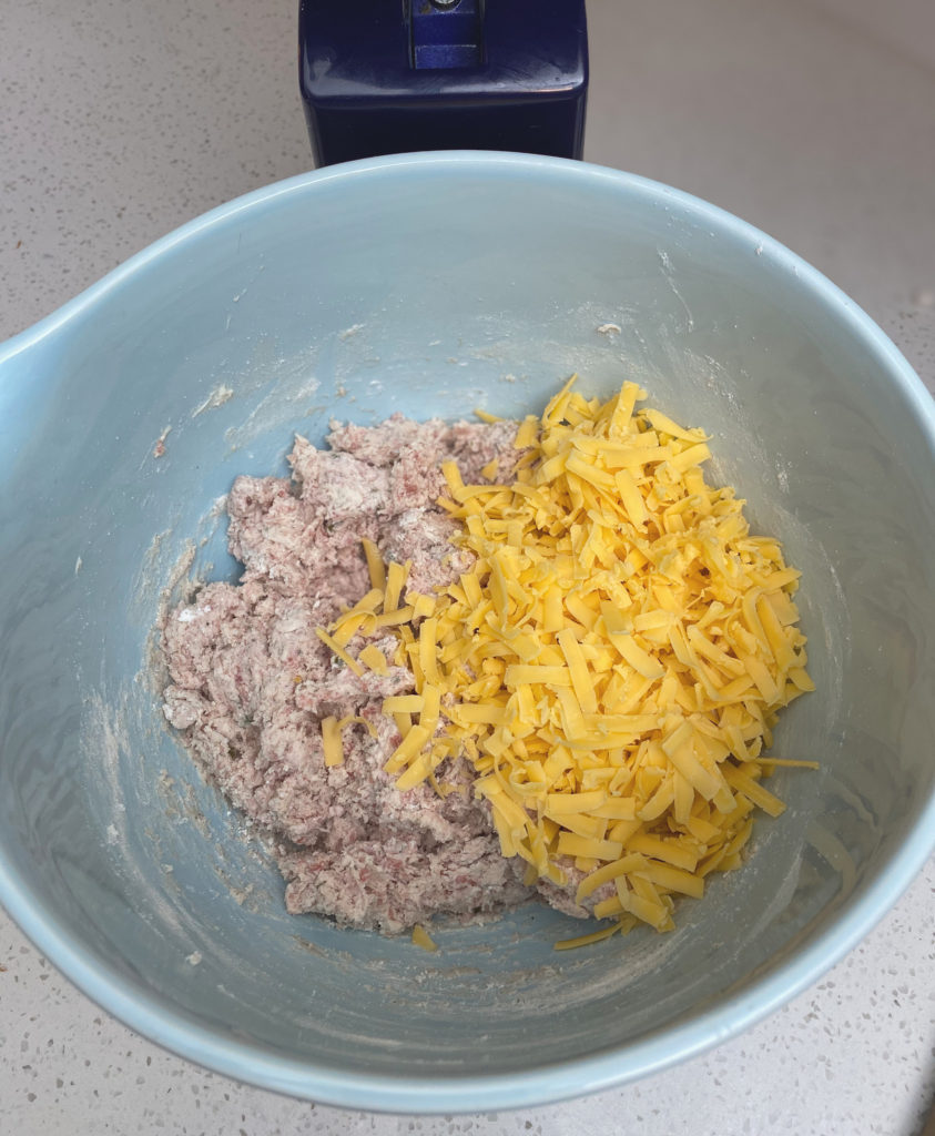 Sausage, cream cheese and Bisquick mixed together with shredded cheese in mixing bowl