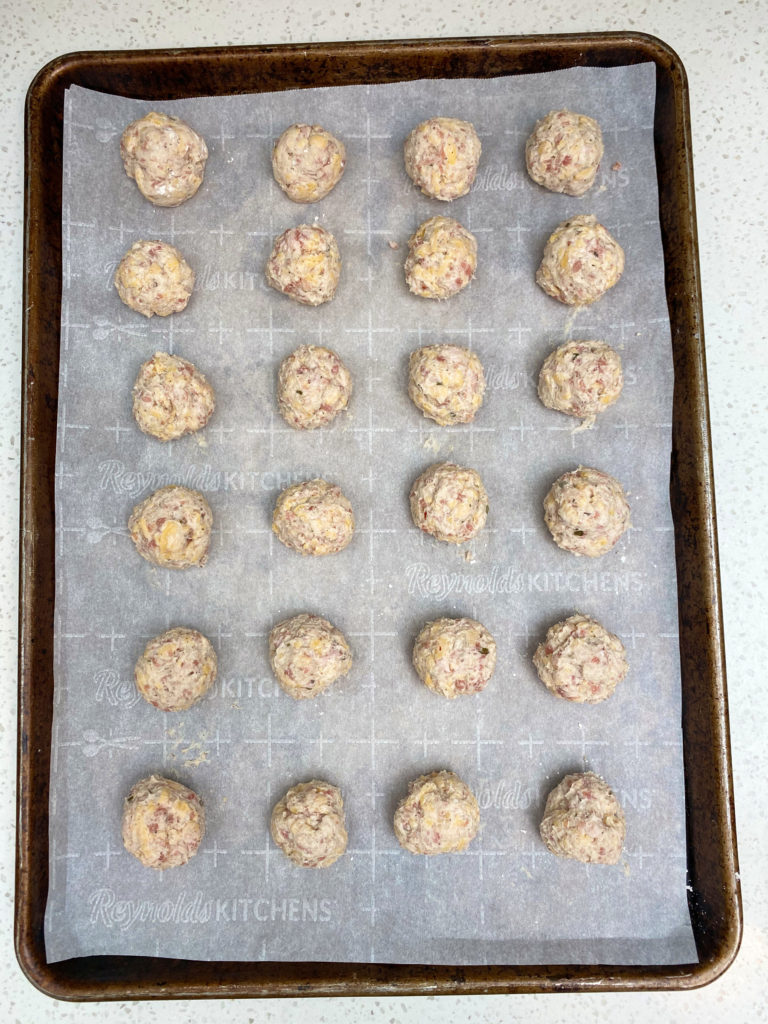 Sausage balls on baking tray after rolling smooth