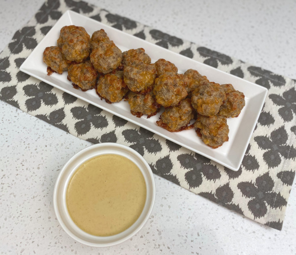 Sausage balls on a tray served with honey mustard dipping sauce