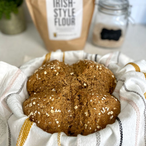 Fresh baked Irish Brown Bread in a basket with a cloth.