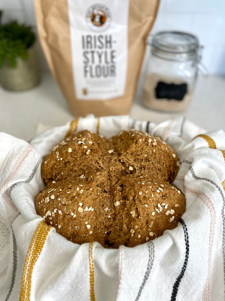 Fresh baked Irish Brown Bread in a basket with a cloth.