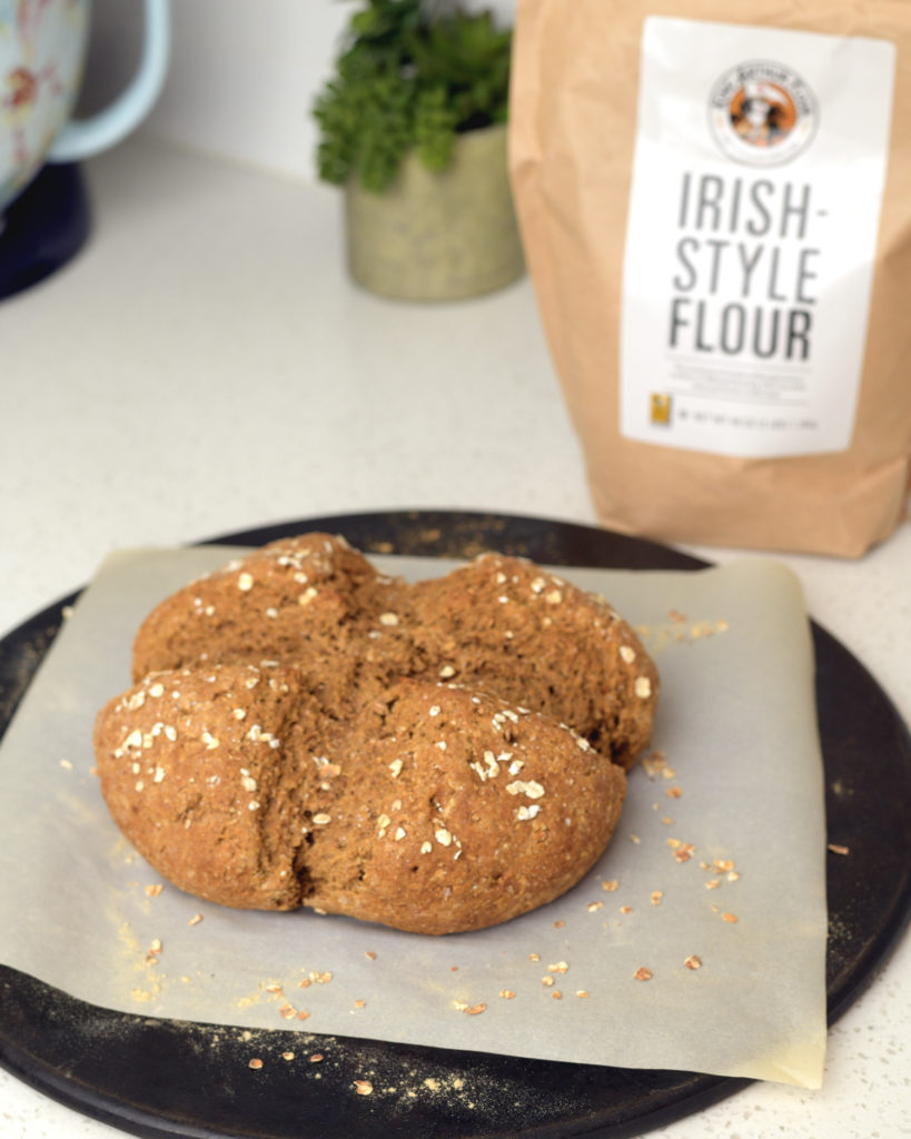 Fresh baked Irish Brown Bread nest to a bag of Irish-style flour