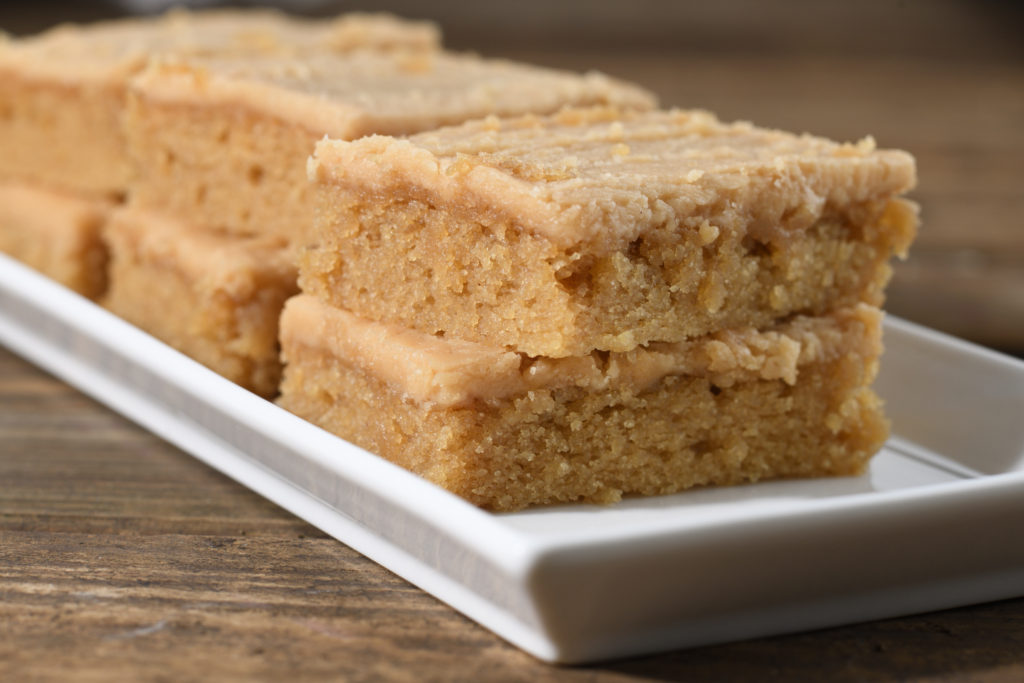 Stacked slices of old fashioned peanut butter sheet cake with peanut butter fudge frosting