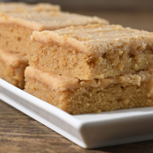 Stacked slices of old fashioned peanut butter sheet cake with peanut butter fudge frosting